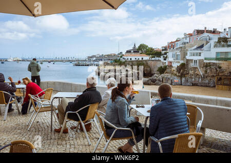 Cascais, distretto di Lisbona, Portogallo : persone sedersi in un caffè all'aperto a Praia da Rainha (Queen's Beach), nel centro di Cascais. Foto Stock