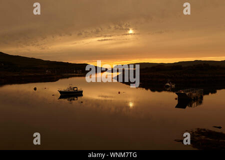 Tramonto sul Loch Tauth Laggan Bay, Ulva, con barche da pesca e boe, Isle of Mull, Scotland, Regno Unito. Foto Stock