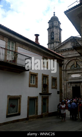 Le persone che lasciano la Chiesa Collegiata di Santa Maria nella vecchia città di Vigo, a nord ovest della Spagna, dell'UE. Foto Stock