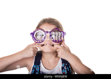 Bambina rendendo silly faccia con colorati occhiali giocattolo. Foto Stock