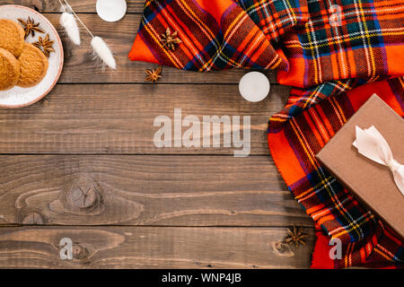 Composizione d'autunno. Moda Donna sciarpa rossa, fiori secchi, i cookie, la confezione regalo, candele. In autunno, casa accogliente, caduta, hygge concetto. Appartamento laico, vista dall'alto, co Foto Stock