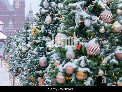 Coperto di neve e gli alberi di Natale con i giocattoli e ghirlande sulla Piazza Rossa di Mosca. Foto Stock