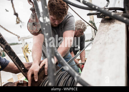 I pescatori commerciali lavorando sul ponte di una nave Foto Stock