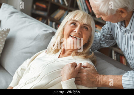 Coppia senior insieme a casa il concetto di pensionamento cercando su ogni altra felice Foto Stock