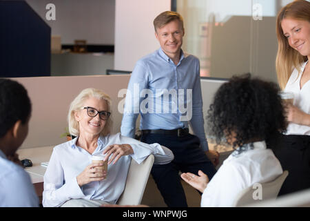 Sorridente diversi dipendenti brainstorm di condividere idee al lavoro Foto Stock
