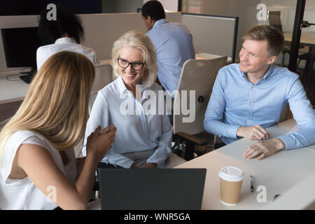 Sorridente colleghi parlare per condividere pensieri al lavoro Foto Stock