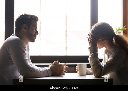 Turbare la donna e uomo che parla in cafe sulle relazioni Foto Stock