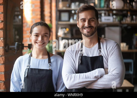 Colpo alla testa ritratto di coffeehouse lavoratori, sorridente cameriere e cameriera Foto Stock