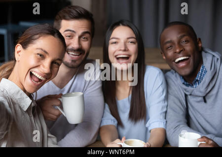 Colpo alla testa ritratto di sorridere diversi amici seduti in cafe insieme Foto Stock