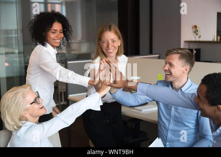 Emozionato diversi colleghi unire le mani che mostra l'unità alla riunione Foto Stock
