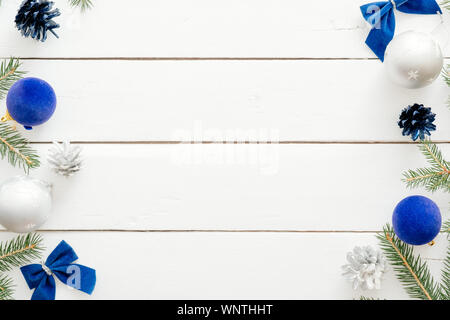 Telaio di natale con palle blu, Abete rami, confezioni regalo, ornamenti in legno su sfondo bianco. Nuovo anno vacanza festosa banner mockup. Christma Foto Stock