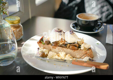 La prima colazione con uova in camicia e tostare il pane in un cafe Foto Stock