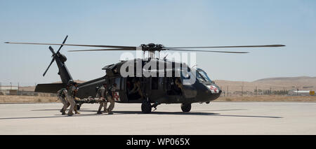 Royal Jordanian soldati dell esercito il carico simulato un incidente in un U.S. Esercito UH-60 Black Hawk, una cellula medevac pilotata da 244combattimento Expeditionary Brigata Aerea, Task Force giavellotto, Task Force Spartan, durante un 9-line medevac evento di formazione in Giordania, Agosto 26, 2019, parte del Jordanian operative Programma di formazione tra gli Stati Uniti Esercito e Giordana forze armate. Per 14 settimane, soldati dal New Jersey esercito guardia nazionale del primo squadrone, 102º Reggimento Calvario, sono giordano per la formazione delle guardie di confine soldati della forza con il 7° Battaglione meccanizzato, 48th brigata meccanizzata in settori quali Foto Stock