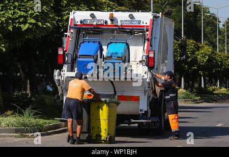 Bucarest, Romania - 29 agosto 2019: due lavoratori servizi igienici svuotare il cestino lattine in un garbage auto, a Bucarest Foto Stock