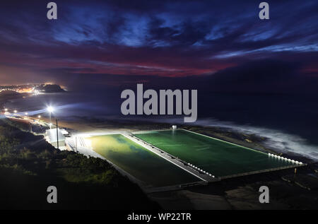 Merewether bagni Oceano all'alba dalla posizione elevata. Questi bagni di mare sono alcuni dei più grandi al mondo e sono un iconico punto di riferimento nella seasid Foto Stock