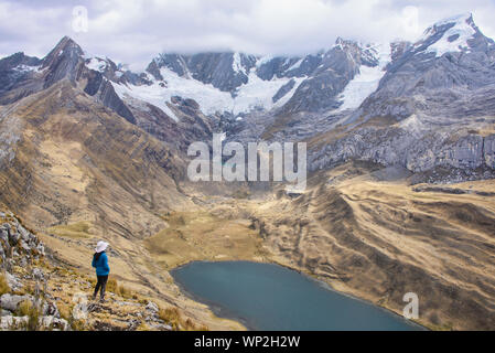 Trekker sopra Laguna Mitacocha, Cordillera Huayhuash circuito, Ancash, Perù Foto Stock