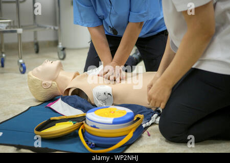 Donna medic dimostra CPR metodi su un manichino di plastica Foto Stock