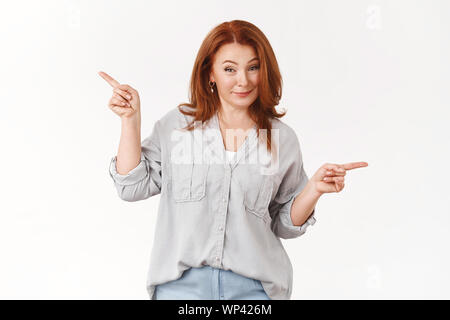 È meglio prendere un look Darling. Assicurato assertivo bella riuscita redhead medio-Le donne più anziane che raccontano awesome promo hinting check out point Foto Stock