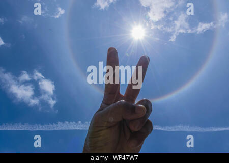 La silhouette sun halo a mezzogiorno con il blu del cielo cloud, il fascio di luce e la lente effetto flare sullo sfondo del tono. Foto Stock