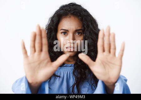 Vittima di abusi, pericolo e donne concetto. Close-up allarmato e grave-cercando african american curly-donna dai capelli allungare le mani avanti in stop motion, Foto Stock