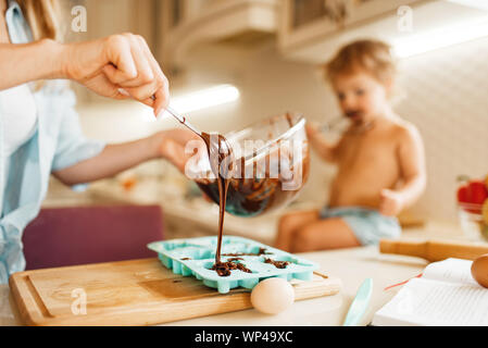 La madre e il bambino per la cottura e i gusti di cioccolato fuso Foto Stock