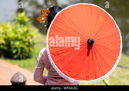 Lo sfondo della tailandese tradizionale ombrellone rosso in stile Lanna, non identificato con donne locali nella regione a nord della Thailandia Foto Stock