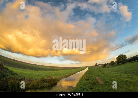 Ampia vista di una doccia thundery oltre il paesaggio olandese al tramonto Foto Stock