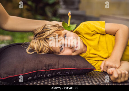 Il ragazzo riceve una procedura con un orecchio candela, bambini le orecchie salute, buona audizione, cerume Foto Stock