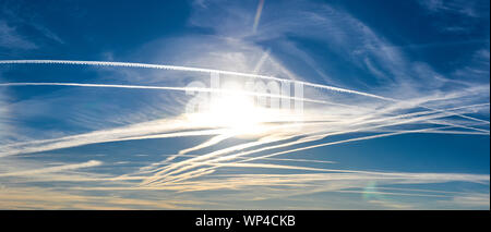 Numero straordinario di aeromobili contrails sotto fresca e chiara windless condizioni su un Marzo giornata di primavera in Spagna. Questi riducono la luce del sole e di un Foto Stock