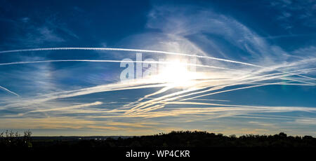 Numero straordinario di aeromobili contrails sotto fresca e chiara windless condizioni su un Marzo giornata di primavera in Spagna. Questi riducono la luce del sole e di un Foto Stock
