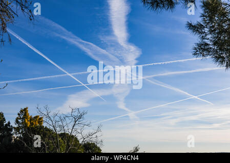 Numero straordinario di aeromobili contrails sotto fresca e chiara windless condizioni su un Marzo giornata di primavera in Spagna. Questi riducono la luce del sole e di un Foto Stock
