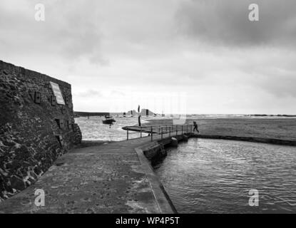 Un pareggiatore solitario sulla spiaggia a Bude in North Cornwall. Un vivace eseguire nonostante l'imminente oscurità di un cielo scuro Foto Stock