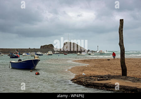 Un uomo e il suo cane godetevi una passeggiata mattutina lungo la spiaggia a Bude, Cornwall più città del nord. Foto Stock