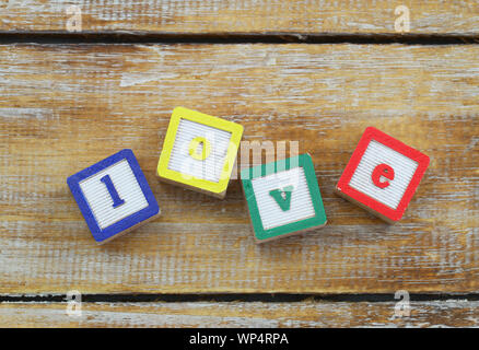 Blocchi di legno con colorate lettere amore sulla superficie rustico Foto Stock