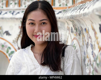 Oung bella donna tailandese pone per la fotocamera a Bangkok il Wat Arun tempio. Foto Stock