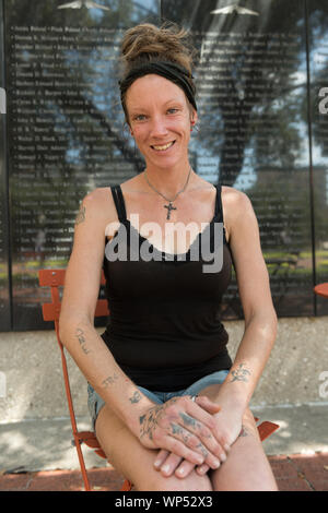 Julie Crawford, che aiuta a prendersi cura di suo padre, Frank Smith, una guerra mondiale II veterano che trascorre molto del suo tempo nelle strade di Fort Worth, si siede di fronte alla parete di aviazione di onore in generale vale la pena di piazza nel centro di Fort Worth, Texas Foto Stock