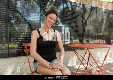 Julie Crawford, che aiuta a prendersi cura di suo padre, Frank Smith, una guerra mondiale II veterano che trascorre molto del suo tempo nelle strade di Fort Worth, si siede di fronte alla parete di aviazione di onore in generale vale la pena di piazza nel centro di Fort Worth, Texas Foto Stock