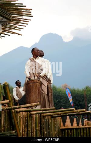 (190907) -- KIGALI, Sett. 7, 2019 (Xinhua) -- Gioco esecutori tradizionali tamburi all annuale i gorilla di montagna cerimonia di denominazione Kwita Izina nel distretto di Musanze, Ruanda, Sett. 6, 2019. Circa 50.000 persone dal Ruanda e all'estero sono state raccogliendo in area Kinigi, Musanze district, dal venerdì mattina e pomeriggio a testimoniare l annuale i gorilla di montagna cerimonia di denominazione Kwita Izina, che è stato introdotto nel 2005 per aumentare la consapevolezza circa la conservazione e per ringraziare europee per la loro persistente e preziosa partecipazione e sostegno per queste iniziative. Per andare con 'Funzione: Ruanda nomi in via di estinzione Foto Stock