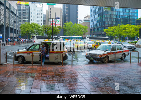 Fukuoka, Giappone - 13 Luglio 2019 - i Taxi stop per far salire e scendere passeggeri di fronte a una stazione ferroviaria edificio a Fukuoka, Giappone sulla luglio 13, 2019 Foto Stock