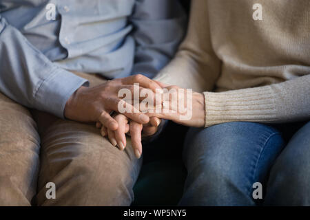 Close up di mezza età giovane famiglia Holding Hands, il supporto. Foto Stock