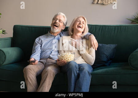 Emozionato coppia matura di ridere mentre si guarda il film di commedia. Foto Stock