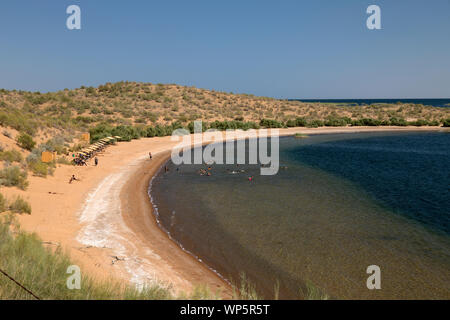 Una spiaggia di sabbia sulla sponda occidentale del Lago di Aidarkul vicino alla città di Nurata in Uzbekistan. persone il nuoto nel lago e prendere il sole. Foto Stock
