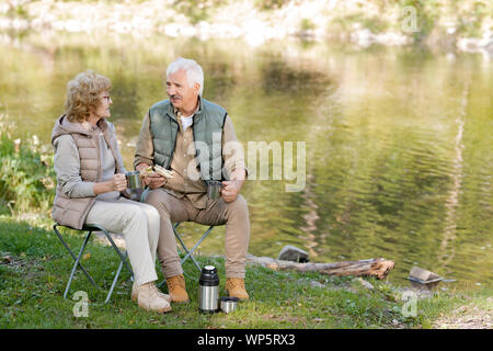 Coppia affettuosa l uomo e la donna in activewear avente un tè con panini Foto Stock