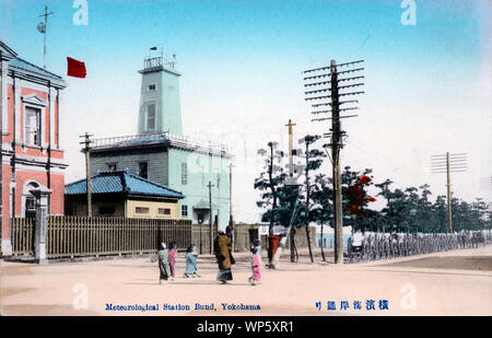 [ 1900 Giappone - Stazione meteorologica nel Porto di Yokohama ] - una lunga fila di riscio di fronte la stazione meteorologica su Kaigandori, noto anche come il Bund, a Yokohama, nella prefettura di Kanagawa. L'edificio di mattoni rossi a fianco è il porto di Kanagawa reparto (神奈川県港務部). Entrambi gli edifici erano situati sulla destra dell'entrata a Yokohama Pier. Pertanto i tanti risciò. Xx secolo cartolina vintage. Foto Stock