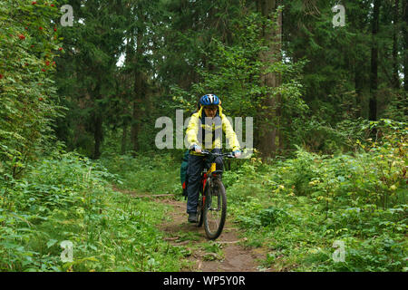 Bicicletta maschio escursionista scorre su un sentiero in autunno di foreste di montagna Foto Stock