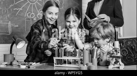 Fare esperimenti con liquidi nel laboratorio di chimica. Ai bambini di esperimenti scientifici. L'istruzione. torna a scuola. laboratorio di chimica. bambini felici insegnante. Utilizzando le moderne tecnologie. Foto Stock