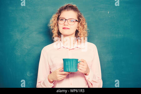 Insegnante della scuola hanno bisogno di pausa caffè. idea e ispirazione. buona mattina. ragazza rinfrescante con bevanda di tè. energia e vigore. ricostituzione delle riserve di energia. donna con la tazza di caffè a Lavagna. Foto Stock