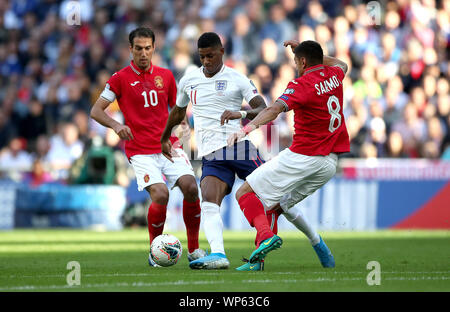 Dell'Inghilterra Rashford Marcus (centro) battaglie per la palla con la Bulgaria Ivelin Popov (sinistra) e Georgi Sarmov (a destra) durante l'Euro 2020 qualifica del Gruppo una partita allo stadio di Wembley, Londra. Foto Stock