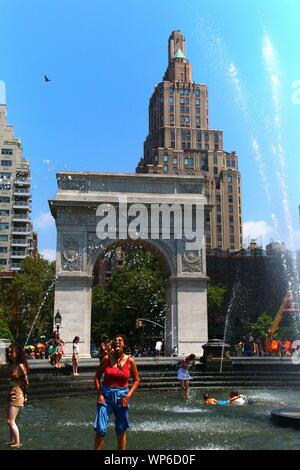 Le persone che si godono le calde giornate estive in Washington Square Park fontana in Manhattan su luglio 19th, 2019 a New York, Stati Uniti d'America. (Foto di Wojciech Migda) Foto Stock