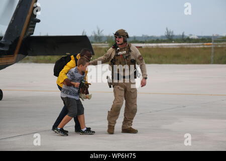 Marsh Harbour, Abaco, Bahamas. 03 Settembre, 2019. Un U.S. Delle dogane e della protezione delle frontiere Salvataggio in elicottero membro di equipaggio aiuta a evacuare un bambino dopo il passaggio dell uragano Dorian Settembre 3, 2019 in Marsh Harbour, Abaco, Bahamas. Dorian ha colpito la piccola isola nazione come una categoria 5 tempesta con venti di 185 km/h. Foto Stock